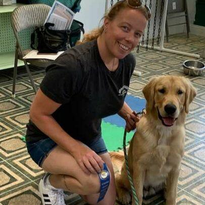 A woman participating in dog training exercises with a golden retriever.
